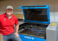 jeremy klein sitting next to omtech laser cutter/engraver